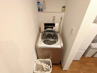 a washing machine in the corner of a room at SunshineHouse \u4eac\u5cf6 \u6210\u7530\u7fbd\u7530\u76f4\u901a \u9002\u54086\u540d\u6700\u59278\u540d in Tokyo