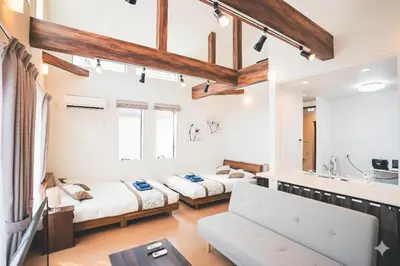 two beds in a room with white walls and wooden ceilings at New! U&I Villa close Disney & Narita AP - Great View in Tokyo