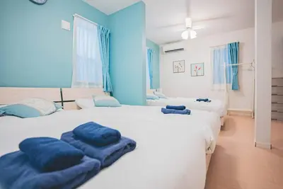 two large beds in a room with blue walls at New! U&I Villa close Disney & Narita AP - Great View in Tokyo