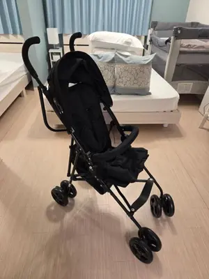 a black stroller sitting on the floor in a bedroom at New! U&I Villa close Disney & Narita AP - Great View in Tokyo