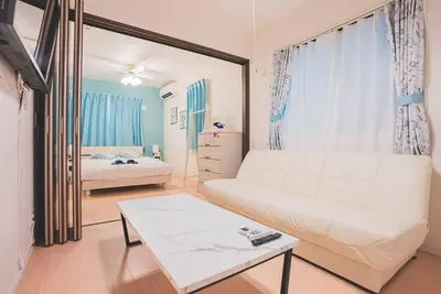 a living room with a white couch and a bed at New! U&I Villa close Disney & Narita AP - Great View in Tokyo