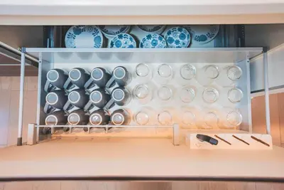 a cabinet filled with plates and bowls in a kitchen at New! U&I Villa close Disney & Narita AP - Great View in Tokyo