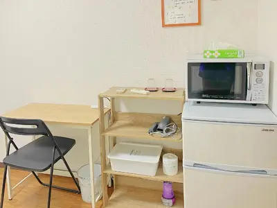 a microwave oven sitting on top of a refrigerator next to a table at Nakano 102 Walking 4 Mins Broadway Shinjuku 1 stop in Tokyo