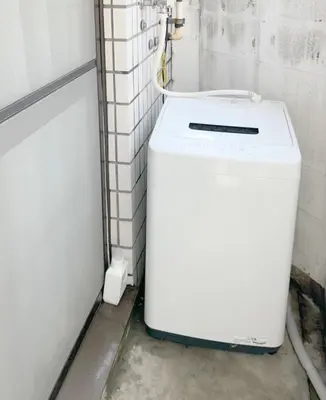 a washer and dryer in a bathroom with a wall at Nakano 102 Walking 4 Mins Broadway Shinjuku 1 stop in Tokyo