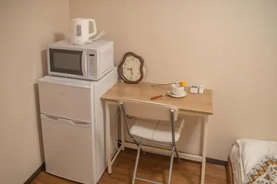 a small table with a microwave and a chair at Nakano 103 Walking 4 Mins Broadway Shinjuku 1 stop in Tokyo