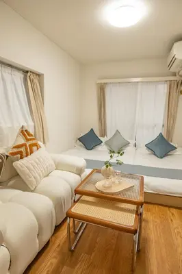 a living room with a white couch and a table at Nakano Walking 4 Mins Broadway Shinjuku 1 stop in Tokyo