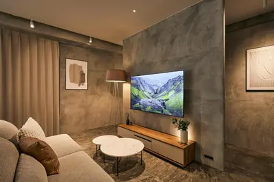 a living room with a couch and a tv on a wall at Spacious Tokyo Base near Tamachi station Hotel Ten Tamachi in Tokyo