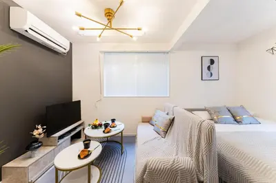 a bedroom with a bed and a tv and a couch at #1 -\u9ad8\u7530\u99ac\u5834\u30a2\u30cd\u30c3\u30af\u30b9- Condo in Tokyo