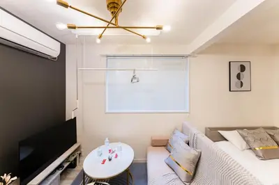a living room with a bed and a tv at #1 -\u9ad8\u7530\u99ac\u5834\u30a2\u30cd\u30c3\u30af\u30b9- Condo in Tokyo