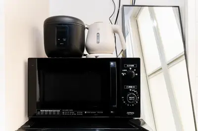 a microwave with a coffee pot on top of it at #1 -\u9ad8\u7530\u99ac\u5834\u30a2\u30cd\u30c3\u30af\u30b9- Condo in Tokyo