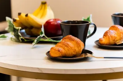 a table with croissants and a cup of coffee and fruit at #1 -\u9ad8\u7530\u99ac\u5834\u30a2\u30cd\u30c3\u30af\u30b9- Condo in Tokyo