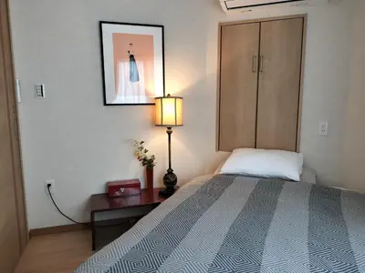 a bedroom with a bed and a lamp and a cabinet at \u6e90\u6c0f\u6c11\u5bbf in Tokyo