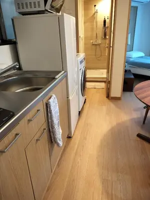 a kitchen with a sink and a refrigerator at \u6e90\u6c0f\u6c11\u5bbf in Tokyo
