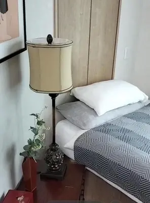 a lamp sitting on a table next to a bed at \u6e90\u6c0f\u6c11\u5bbf in Tokyo