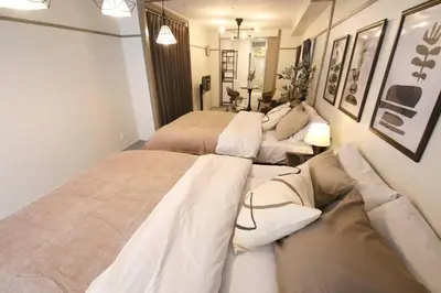 a room with two beds and a couch at \u30aa\u30b0\u30e9\u30d3\u30eb 205 in Tokyo