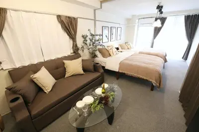 a living room with a couch and a bed at \u30aa\u30b0\u30e9\u30d3\u30eb 205 in Tokyo