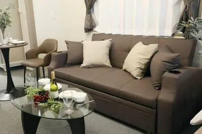 a living room with a couch and a glass table at \u30aa\u30b0\u30e9\u30d3\u30eb 205 in Tokyo