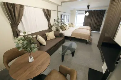 a living room with a couch and a table at \u30aa\u30b0\u30e9\u30d3\u30eb 205 in Tokyo