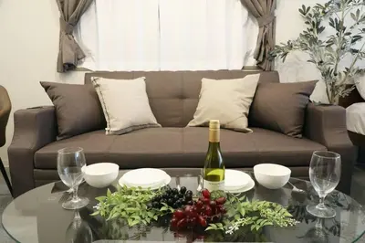 a living room with a couch and a table with wine glasses at \u30aa\u30b0\u30e9\u30d3\u30eb 205 in Tokyo