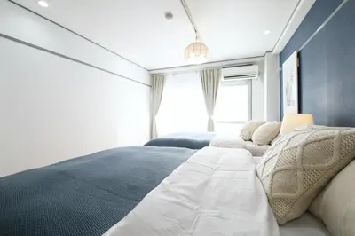 a bedroom with two beds and a window at \u30aa\u30b0\u30e9\u30d3\u30eb 403 in Tokyo