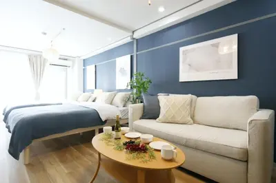 a living room with a bed and a couch and a table at \u30aa\u30b0\u30e9\u30d3\u30eb 403 in Tokyo