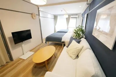 a living room with a couch and a table and a tv at \u30aa\u30b0\u30e9\u30d3\u30eb 403 in Tokyo