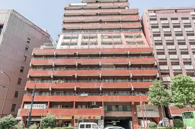 a tall brick building in front of two tall buildings at Kiwami Hotel Shinjuku in Tokyo