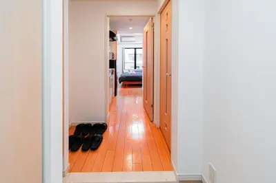 a hallway with black shoes on the floor at Mio Hotel Shinjuku Tokyo in Tokyo