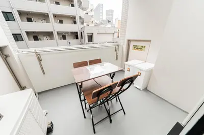 a room with a table and chairs on a balcony at Mio Hotel Shinjuku Tokyo in Tokyo