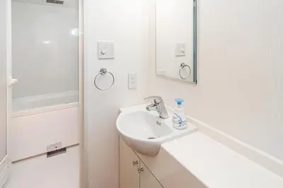 a white bathroom with a sink and a mirror at Mio Hotel Shinjuku Tokyo in Tokyo