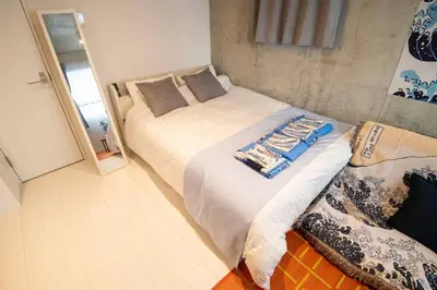 a bedroom with two beds and a mirror at 24\u5e748\u6708\u65b0\u7bc910\u6708\u30aa\u30fc\u30d7\u30f3 \u738b\u5b50\u99c5\u5f92\u6b695\u5206 \u4e38\u8cb8\u5207\u308b \u6700\u59274\u4eba 2b\u5ba4 in Tokyo