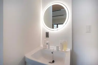 a white bathroom with a sink and a mirror at Blossom House Akasaka301 in Tokyo