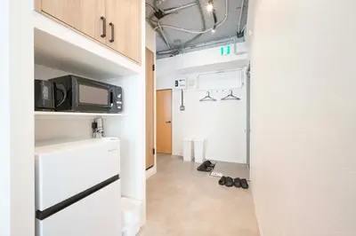 a small room with a kitchen and a microwave at Blossom House Akasaka301 in Tokyo
