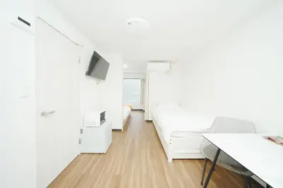 a white room with a bed and a desk at \u6771\u4eac\u30ea\u30ea\u30a2\u30eb\u30db\u30c6\u30eb0501 in Tokyo