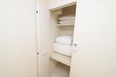 a closet with white towels on a shelf at NYHotel 2 \u65b0\u5bbf2\u968e\u5efa\u30663\u5ba41\u30d0\u30b9\u30eb\u30fc\u30e01\u30b7\u30e3\u30ef\u30fc2\u30c8\u30a4\u30ec in Tokyo