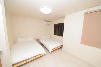 two beds in a small room with a window at NYHotel 2 \u65b0\u5bbf2\u968e\u5efa\u30663\u5ba41\u30d0\u30b9\u30eb\u30fc\u30e01\u30b7\u30e3\u30ef\u30fc2\u30c8\u30a4\u30ec in Tokyo