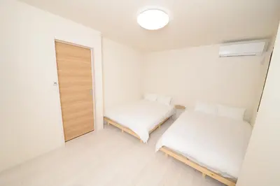 a room with two beds and a mirror at NYHotel 2 \u65b0\u5bbf2\u968e\u5efa\u30663\u5ba41\u30d0\u30b9\u30eb\u30fc\u30e01\u30b7\u30e3\u30ef\u30fc2\u30c8\u30a4\u30ec in Tokyo