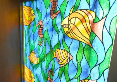 a stained glass window with fish in the water at Rooftop Haven \u65b0\u5c0f\u5ca9 in Tokyo