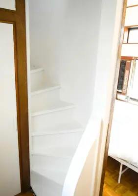 a stairwell in a bedroom with white walls at Rooftop Haven \u65b0\u5c0f\u5ca9 in Tokyo