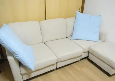 a white couch with two blue pillows on it at Rooftop Haven \u65b0\u5c0f\u5ca9 in Tokyo