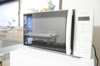 a microwave oven on a counter with a table inside at Rooftop Haven \u65b0\u5c0f\u5ca9 in Tokyo