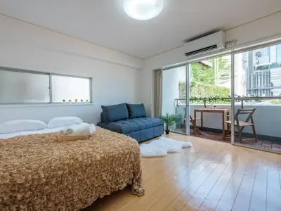 a bedroom with a bed and a couch and a table at Tokyo Stay Akasaka in Tokyo