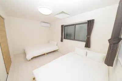 a room with two beds and a window at NYHotel 3 \u65b0\u5bbf2\u968e\u5efa\u30663\u5ba41\u30d0\u30b9\u30eb\u30fc\u30e01\u30b7\u30e3\u30ef\u30fc2\u30c8\u30a4\u30ec in Tokyo