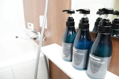 a group of bottles sitting on a shelf in a bathroom at NYHotel 3 \u65b0\u5bbf2\u968e\u5efa\u30663\u5ba41\u30d0\u30b9\u30eb\u30fc\u30e01\u30b7\u30e3\u30ef\u30fc2\u30c8\u30a4\u30ec in Tokyo