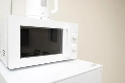 a microwave oven on top of a white cabinet at NYHotel 3 \u65b0\u5bbf2\u968e\u5efa\u30663\u5ba41\u30d0\u30b9\u30eb\u30fc\u30e01\u30b7\u30e3\u30ef\u30fc2\u30c8\u30a4\u30ec in Tokyo
