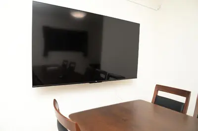 a dining room table with a large flat screen tv on a wall at NYHotel 5 \u65b0\u5bbf2\u968e\u5efa\u30664\u5ba41\u30d0\u30b9\u30eb\u30fc\u30e01\u30b7\u30e3\u30ef\u30fc2\u30c8\u30a4\u30ec in Tokyo