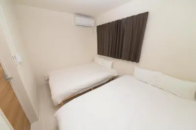 a small room with two beds and a window at NYHotel 5 \u65b0\u5bbf2\u968e\u5efa\u30664\u5ba41\u30d0\u30b9\u30eb\u30fc\u30e01\u30b7\u30e3\u30ef\u30fc2\u30c8\u30a4\u30ec in Tokyo