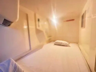 a small room with a bed in a hospital room at Capsule Inn Otsuka in Tokyo