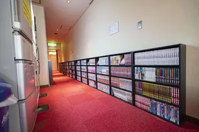 a room with shelves of dvds on the wall at Capsule Inn Otsuka in Tokyo