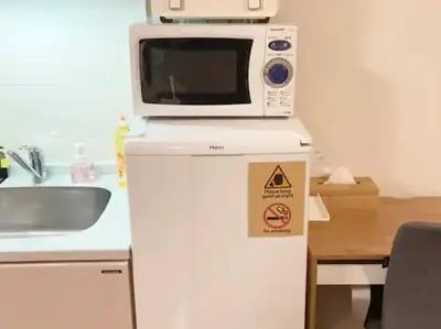 a microwave on top of a refrigerator in a kitchen at \u30ec\u30ac\u30ea\u30a2\u30d2\u30eb\u30ba402 in Tokyo